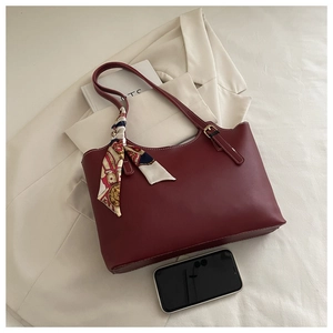 Detail of burgundy tote bag with floral silk scarf handle and phone for size scale