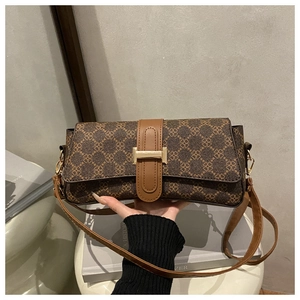 Detail of vintage baguette shoulder bag with brown floral monogram and gold metal buckle