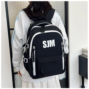 Detailed back view of a high-capacity black and white backpack with SJM logo on a model