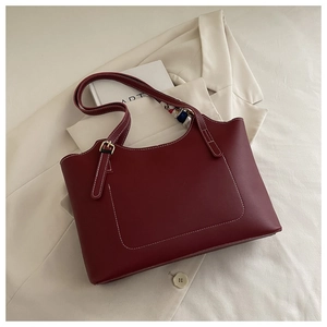 Detail of burgundy leather tote with white stitching, silk scarf and gold buckle