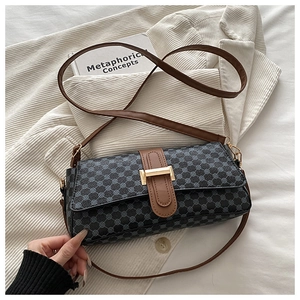 Detail of vintage geometric pattern shoulder bag with a gold buckle on white jacket