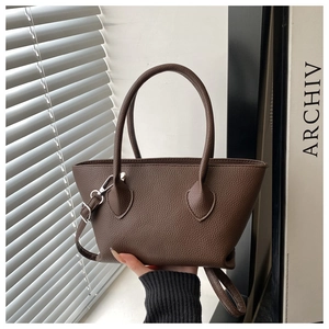 Close-up of dark brown litchi pattern leather handbag with dual cylindrical handles