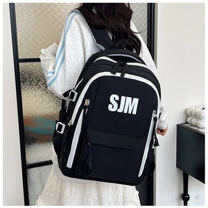 Detail view of a black and white backpack with SJM logo and adjustable side buckles