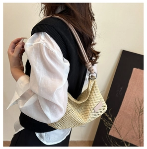 Detail of woven mesh texture and pink leather knotted strap on a summer straw bag
