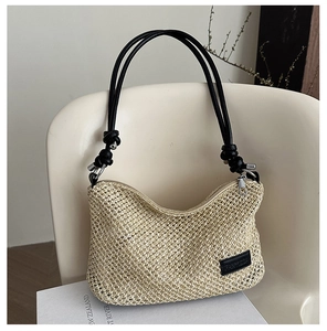 Detailed close-up of woven straw handbag on a white chair with elegant black leather brand tag