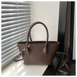 Detailed view of dark brown lychee pattern bucket bag with silver hardware and strap