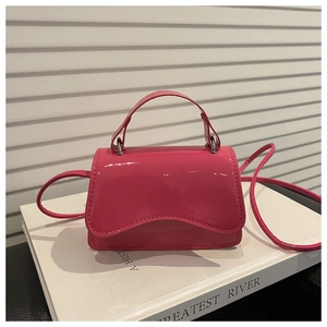 Detail of rose pink patent leather crossbody bag with wave edge flap and silver hardware