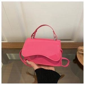 Detail of hot pink patent leather mini crossbody bag with unique scalloped edge flap cover