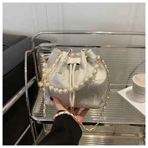 Detailed view of floral embroidery on a satin bucket bag with elegant pearl chain handle