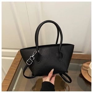 Detailed view of black pebbled leather texture and silver buckle on a stylish bucket bag