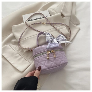 Detail of lavender quilted mini bucket bag with silk scarf bow and gold chain strap