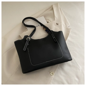 Detail of black tote bag with white contrast stitching and decorative floral silk scarf