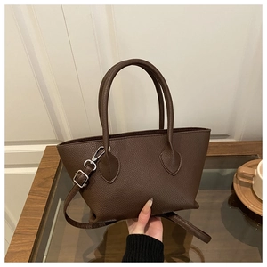 Detail of dark brown lychee pattern bucket bag with silver buckle and detachable strap