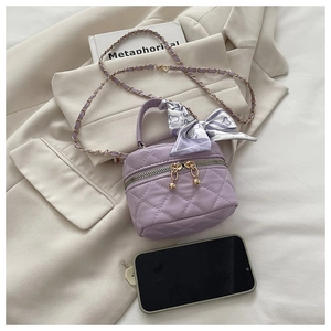 Mini quilted lavender bucket bag with silk scarf and chain strap compared to smartphone
