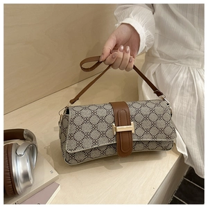 Detail of printed crossbody bag featuring golden H-clasp and leather shoulder strap