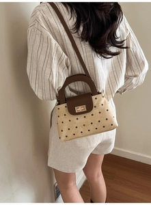 Détail du sac bandoulière vintage à pois avec fermoir doré et sangle ajustable