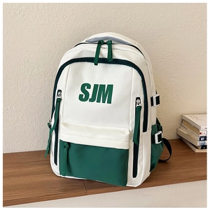 Close-up of white and green school backpack with SJM logo on a wooden shelf