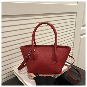 Detail of red lychee grain leather bucket bag with silver hardware and handle