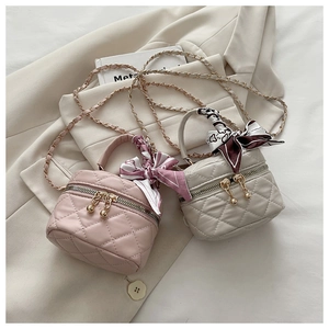 Detail of mini bucket bags with quilted texture, silk scarves and chain straps