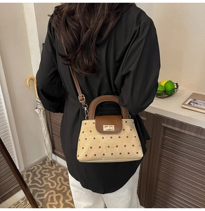 Détail du sac à main beige à pois avec bandoulière marron et fermoir doré brillant