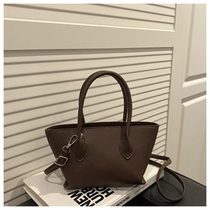 Detail of dark brown pebble leather bucket bag with silver hardware and dual handles