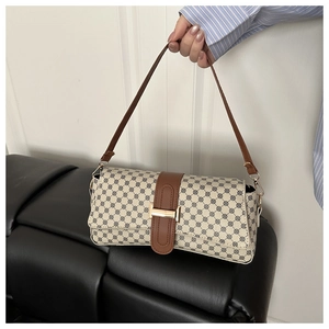 Close-up of vintage geometric print handbag with brown leather strap and gold buckle