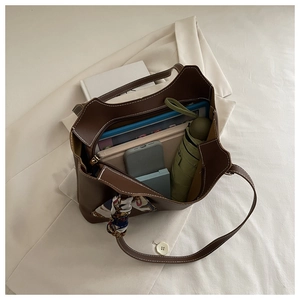 Brown leather tote bag featuring contrast stitching and organized interior items