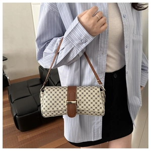 Detail of printed crossbody bag featuring geometric patterns and brown leather strap