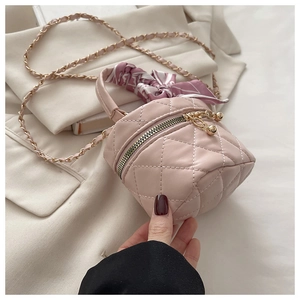 Detailed view of pink quilted mini bucket bag with chain strap and silk scarf handle