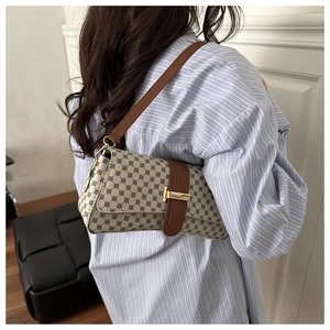 Detail of retro vintage canvas shoulder bag with geometric print and gold metal buckle