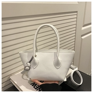 Detailed close-up of white lychee leather texture on a stylish bucket bag with silver hardware