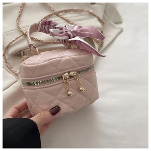 Close-up of pink quilted mini bucket bag with silk scarf handle and gold chain strap