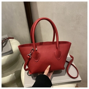 Detailed macro view of red lychee pattern leather texture and dual vertical handles