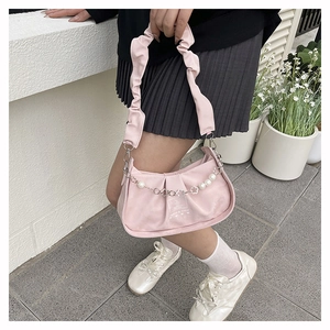Close-up of pink ruched suede shoulder bag with pearl and floral metal chain details