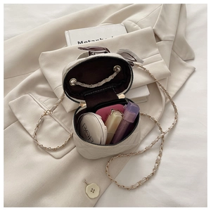 Detail of a beige quilted bucket bag showing interior storage for small cosmetics