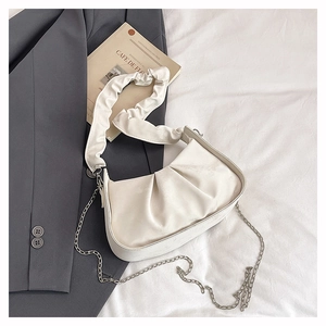 Detail of off-white pleated cloud bag showing leather texture and silver chain strap