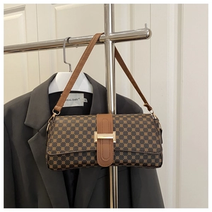 Detail of vintage textured crossbody bag with floral print and gold metal buckle