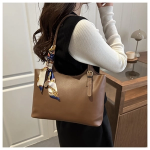 Brown faux leather tote bag detail with silk scarf handle on model's shoulder