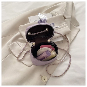 Detail view of mini quilted bucket bag in purple with chain strap and scarf decor