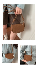 Detail of a brown crescent crossbody bag featuring adjustable knot straps and silver hardware