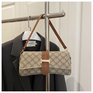 Close-up of vintage print shoulder bag with brown leather trim and golden metal buckle