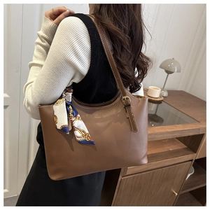 Detailed back view of a brown tote bag with vintage silk scarf and gold chain on shoulder