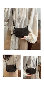 Detail view of deep brown saddle crossbody bag with knot shoulder strap and zipper closure