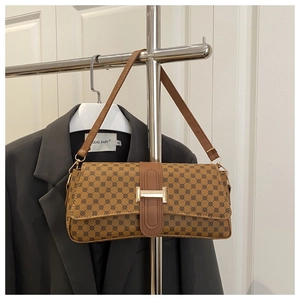 Detail of vintage brown printed baguette bag with golden metal buckle and wide strap