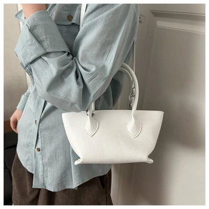 Detailed close-up of white pebble leather texture on a compact fashion bucket bag