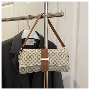 Detail of vintage baguette bag with geometric print and gold metal buckle strap