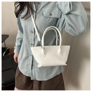 Close-up of white pebble leather bucket bag with silver hardware and detachable strap