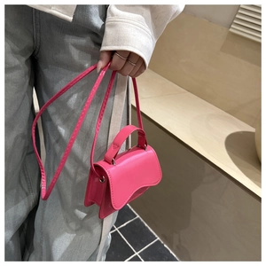 Detail view of mini rose pink patent leather crossbody bag with top handle and strap