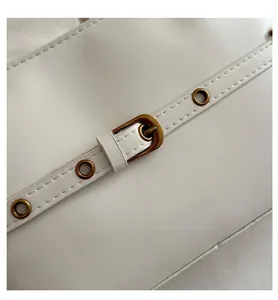 Close-up of white oil wax leather handbag showing fine texture and bronze metal eyelets