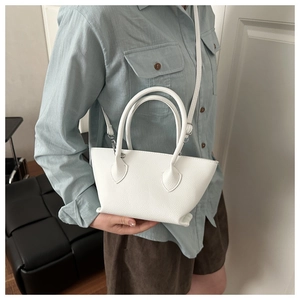 Close-up of white lychee pattern leather bucket bag with silver metal hardware and handle